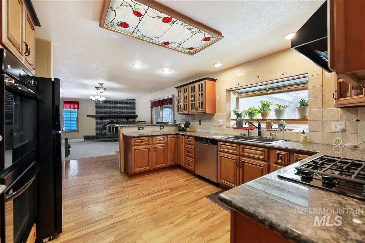 11875 West Hidden Valley Rim Road Boise, ID 83709 - Photo 10 of 36 Kitchen featuring glass insert cabinets, wood finish cabinets, decorative backsplash, and recessed lighting