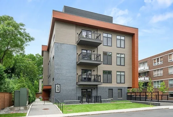 a front view of a residential apartment building with a yard