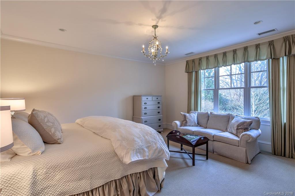 2000 Harris Road Charlotte, NC 28211 - Photo 22 of 34 a spacious bedroom with a bed and a chandelier