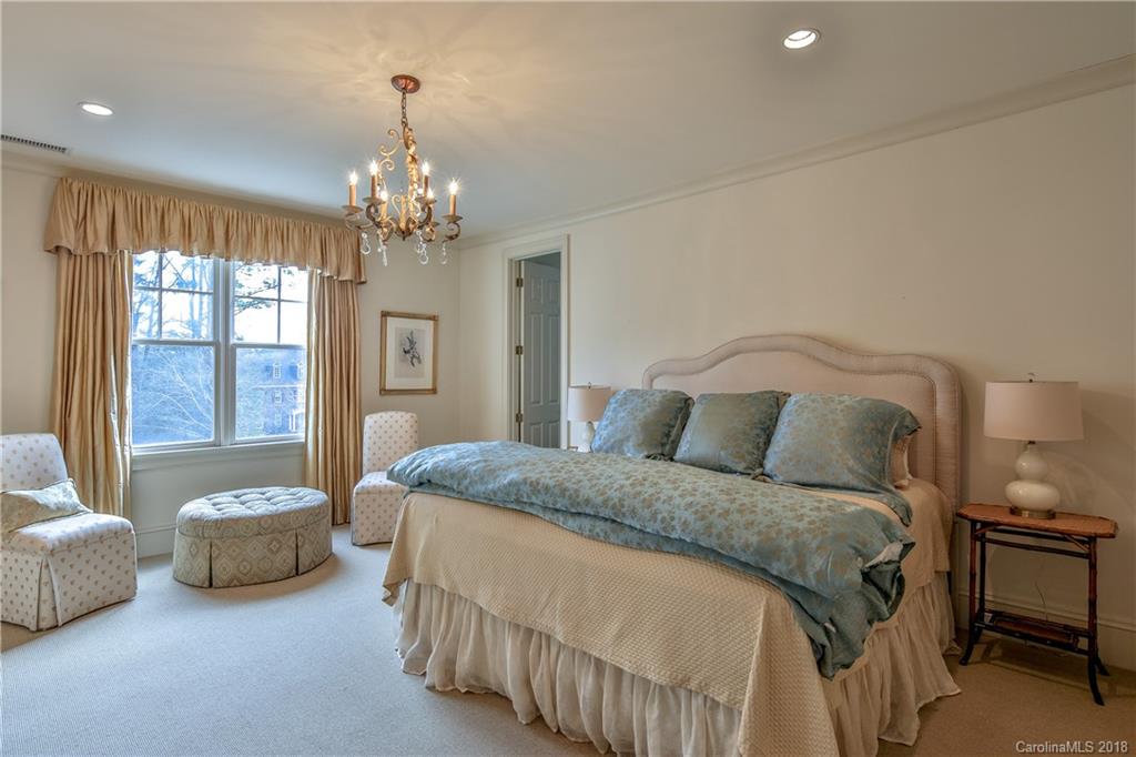 2000 Harris Road Charlotte, NC 28211 - Photo 24 of 34 a spacious bedroom with a bed and a chandelier