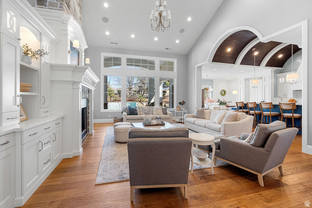 2917 Old Farm Road Washington, UT 84780 - Photo 31 of 105 Living area featuring vaulted ceiling, a fireplace, light wood-style floors, and a chandelier