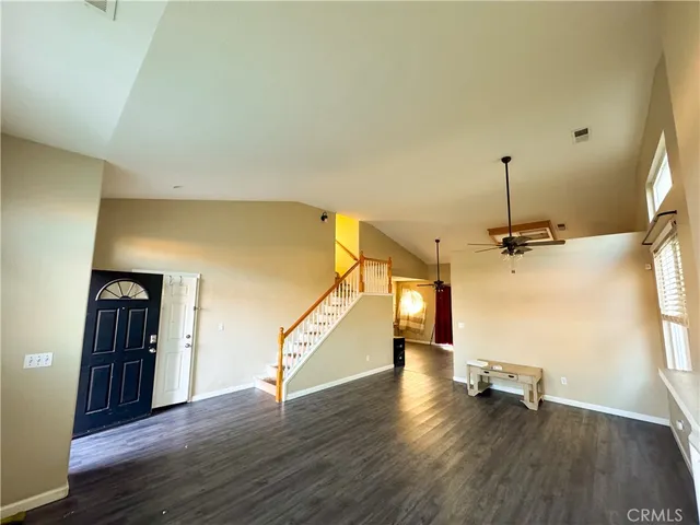 a view of a room with wooden floor staircase and a kitchen