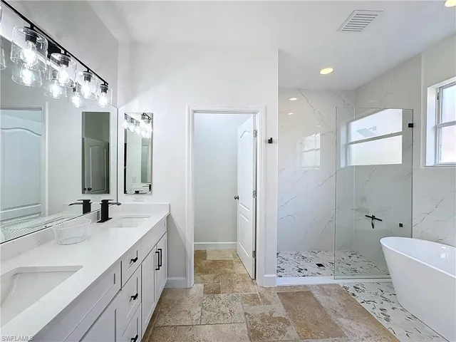 a bathroom with a bathtub shower sink and mirror