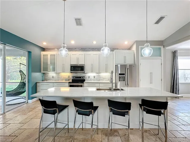 a kitchen with a dining table chairs and cabinets