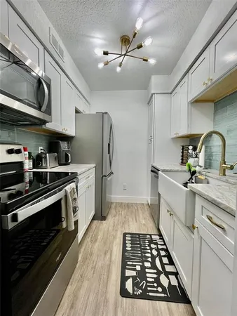 a kitchen with stainless steel appliances a stove a sink and cabinets
