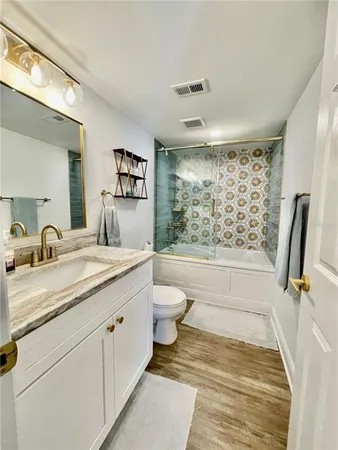 a bathroom with a granite countertop sink toilet and shower