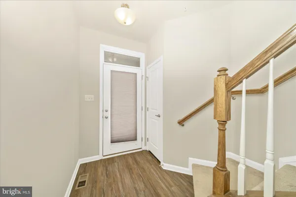 a view of hallway with stairs and wooden floor