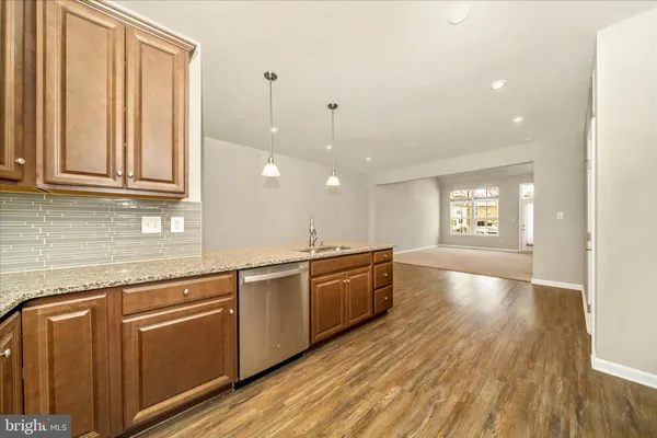 a large kitchen with cabinets wooden floor and stainless steel appliances