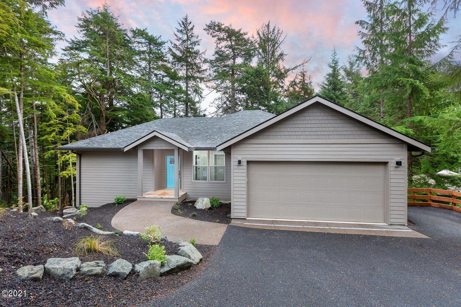 15 Big Tree Road Gleneden Beach, OR 97388 - Photo 1 of 28 a front view of a house with a yard and garage