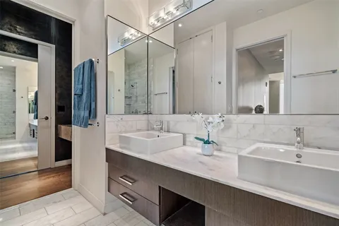a bathroom with double sink and a mirror