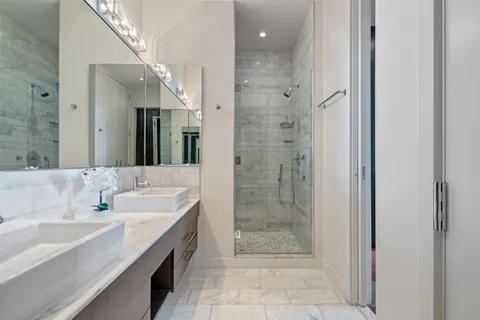 a spacious bathroom with a shower sink and mirror
