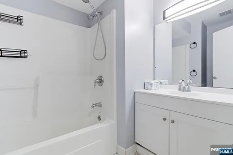 a bathroom with a sink a mirror a shower and a bathtub