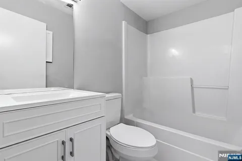 a bathroom with a granite countertop toilet a sink and a bathtub