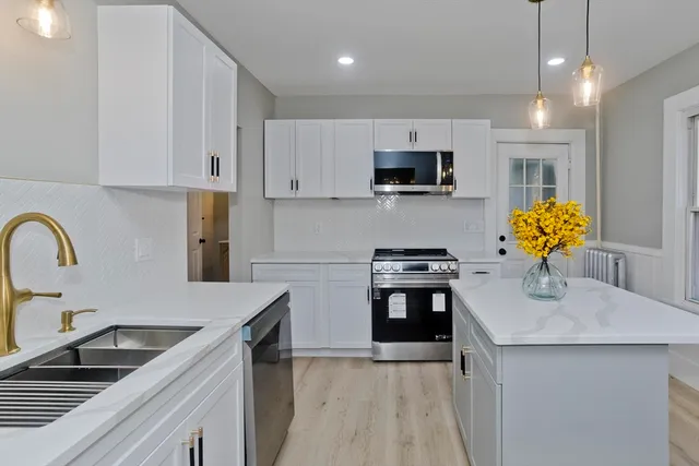 a kitchen with stainless steel appliances granite countertop a sink a stove top oven a counter space and cabinets