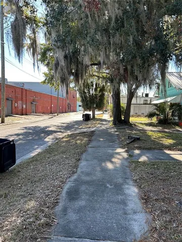 a view of a street with a building and trees