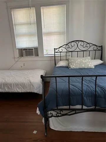 a bedroom with a bed and two window