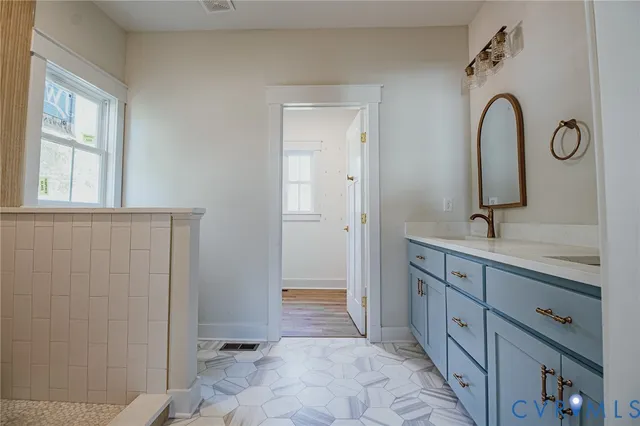 a spacious bathroom with a double vanity sink a mirror and a shower