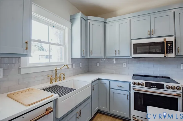 a kitchen with cabinets appliances a sink and a window