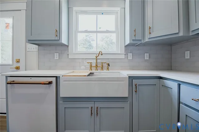 a kitchen with stainless steel appliances granite countertop a sink dishwasher a refrigerator and cabinets with wooden floor