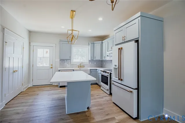 a kitchen with kitchen island white cabinets and stainless steel appliances