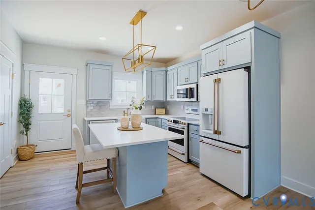 a kitchen with refrigerator cabinets and wooden floor
