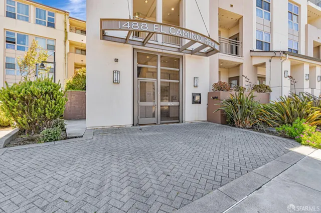 a front view of a building with a garden