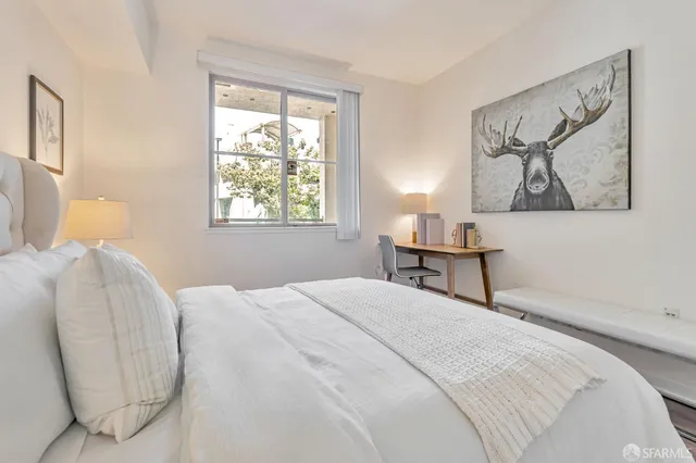 a bedroom with a bed and a painting on the wall