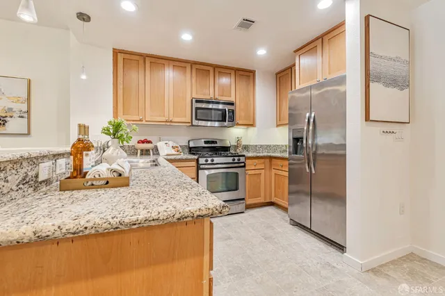 a kitchen with a refrigerator a sink and a stove top oven