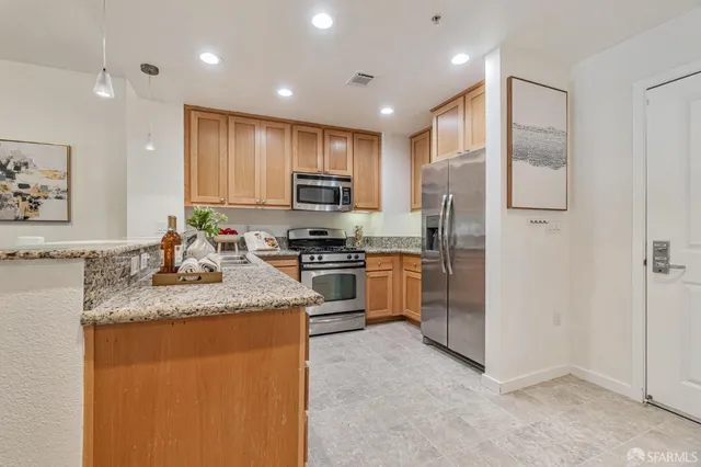 a kitchen with stainless steel appliances granite countertop a refrigerator sink stove microwave and cabinets
