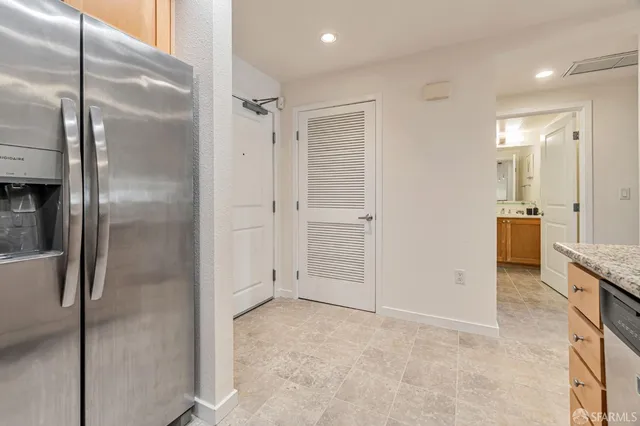 a view of a hallway with stainless steel appliances