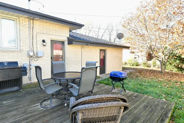 a view of a patio with table and chairs potted plants and wooden floor