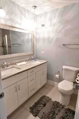a spacious bathroom with a toilet a sink and mirror