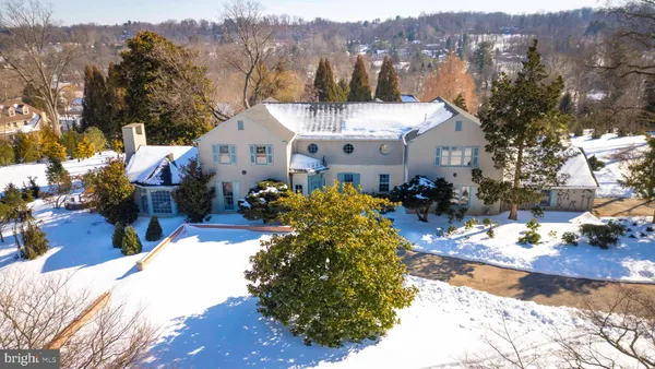 a view of a white house with a yard covered in snow