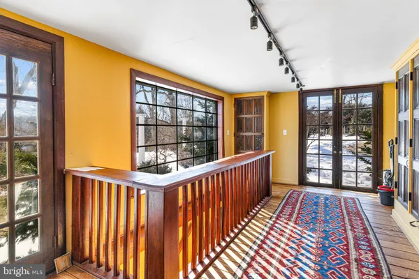 a view of a hallway with wooden floor windows and a chandelier