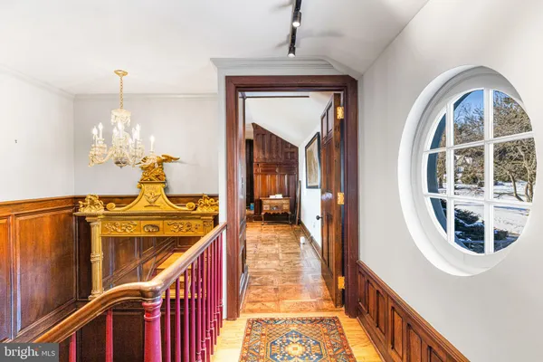 a view of a hallway with wooden floor and a door