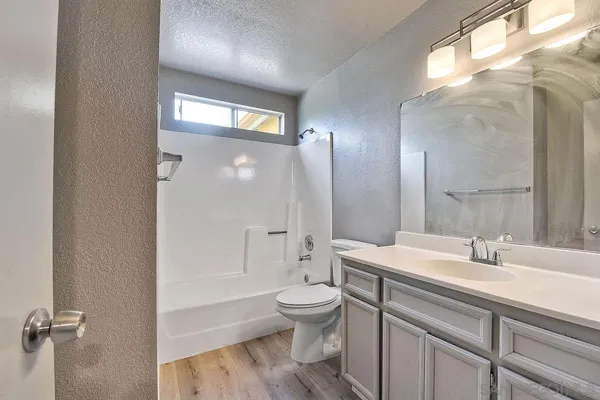 a bathroom with a sink a toilet and a large mirror