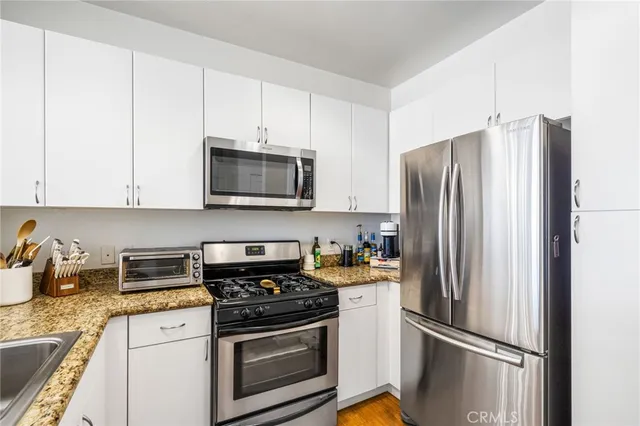 a kitchen with refrigerator a microwave a stove and cabinets