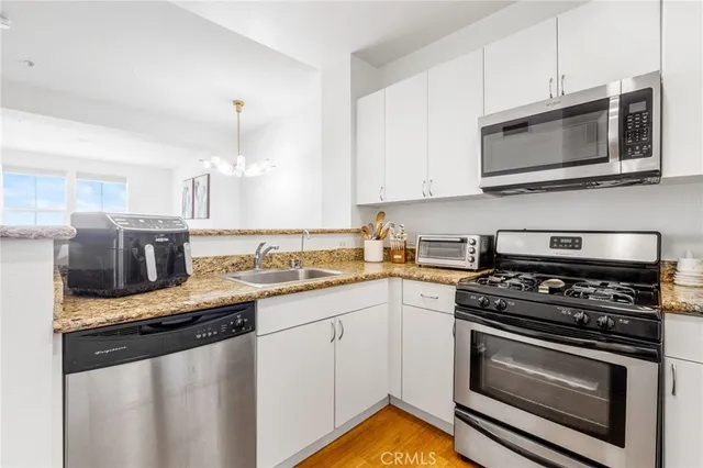 a kitchen with stainless steel appliances granite countertop a stove microwave sink and refrigerator