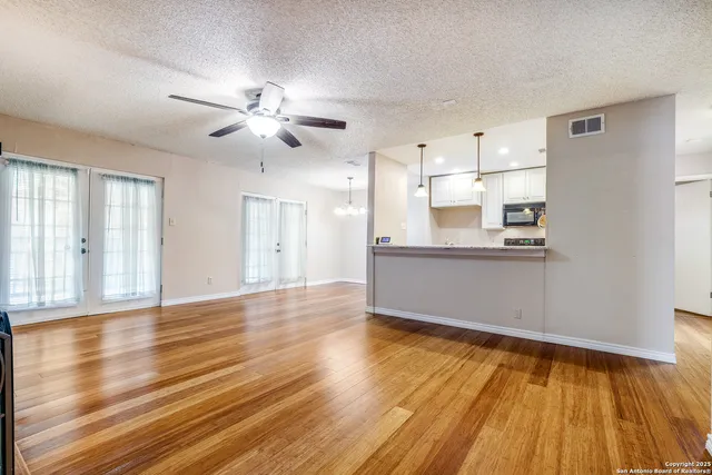 a view of a kitchen with wooden floor and a kitchen space