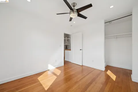 a view of a big room with wooden floor and a ceiling fan