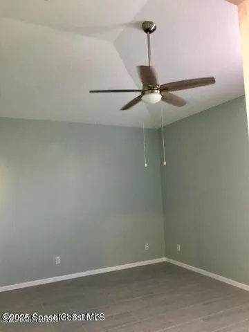 a view of an empty room with closet and a window