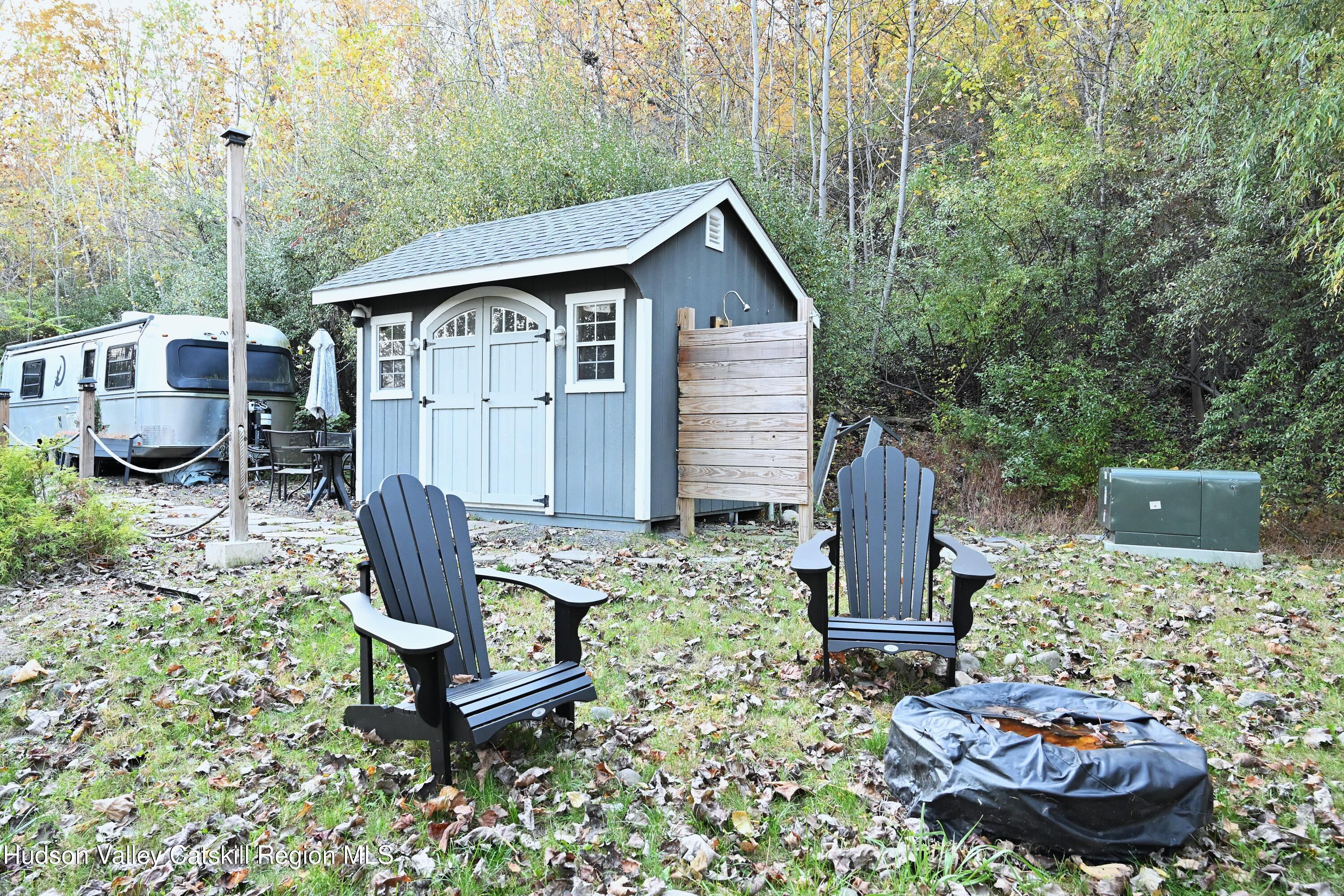 275 Creek Locks Road Rosendale, NY 12472 - Photo 14 of 23 a view of a backyard with table and chairs potted plants with wooden fence