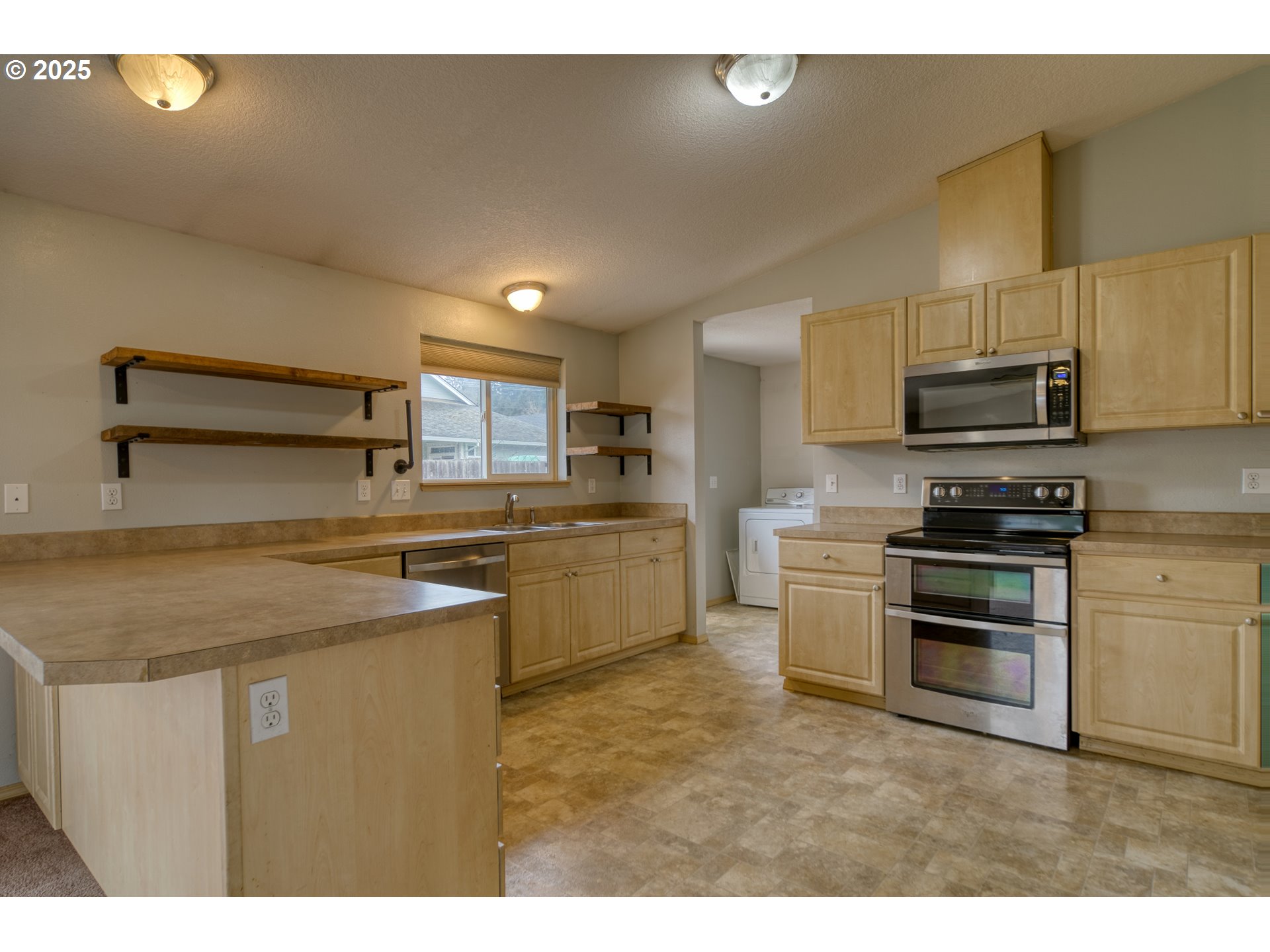 34122 Adison Street Scappoose, OR 97056 - Photo 12 of 41 a kitchen with kitchen island a sink stainless steel appliances and cabinets