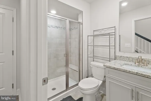 a bathroom with a granite countertop sink toilet and shower