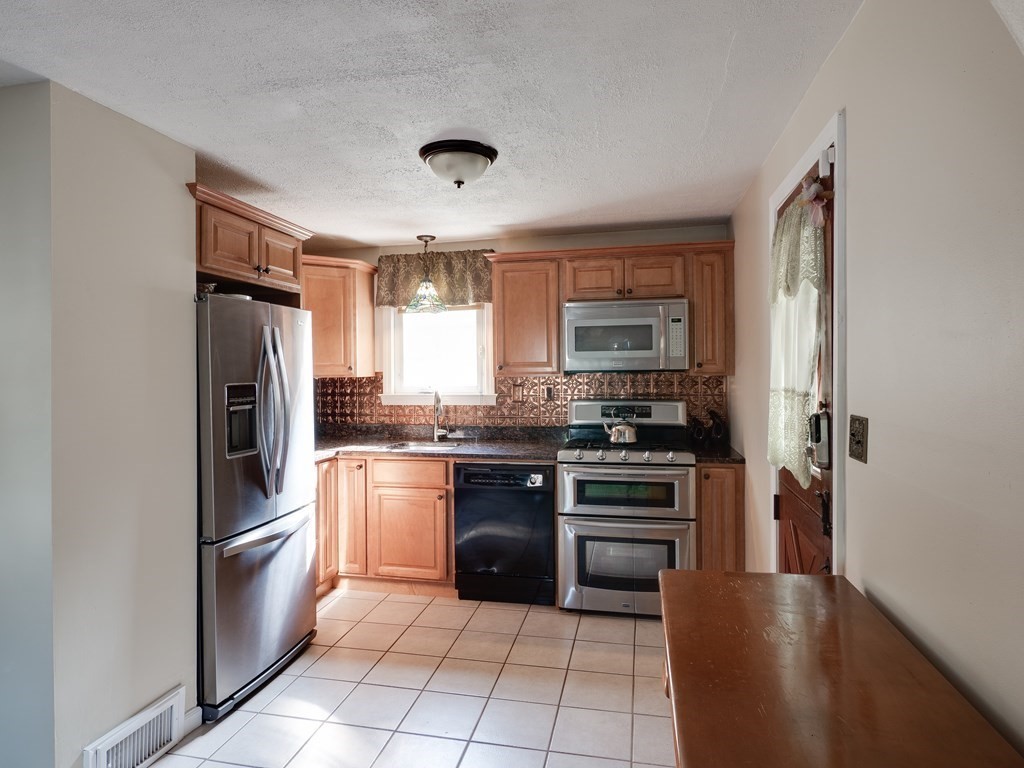 357 Massachusetts Avenue West Springfield, MA 01089 - Photo 3 of 22 a kitchen with stainless steel appliances granite countertop a refrigerator stove and sink