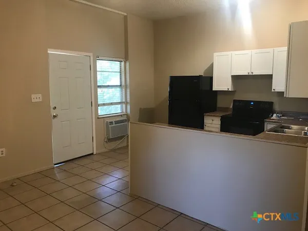 a kitchen with a refrigerator and a stove