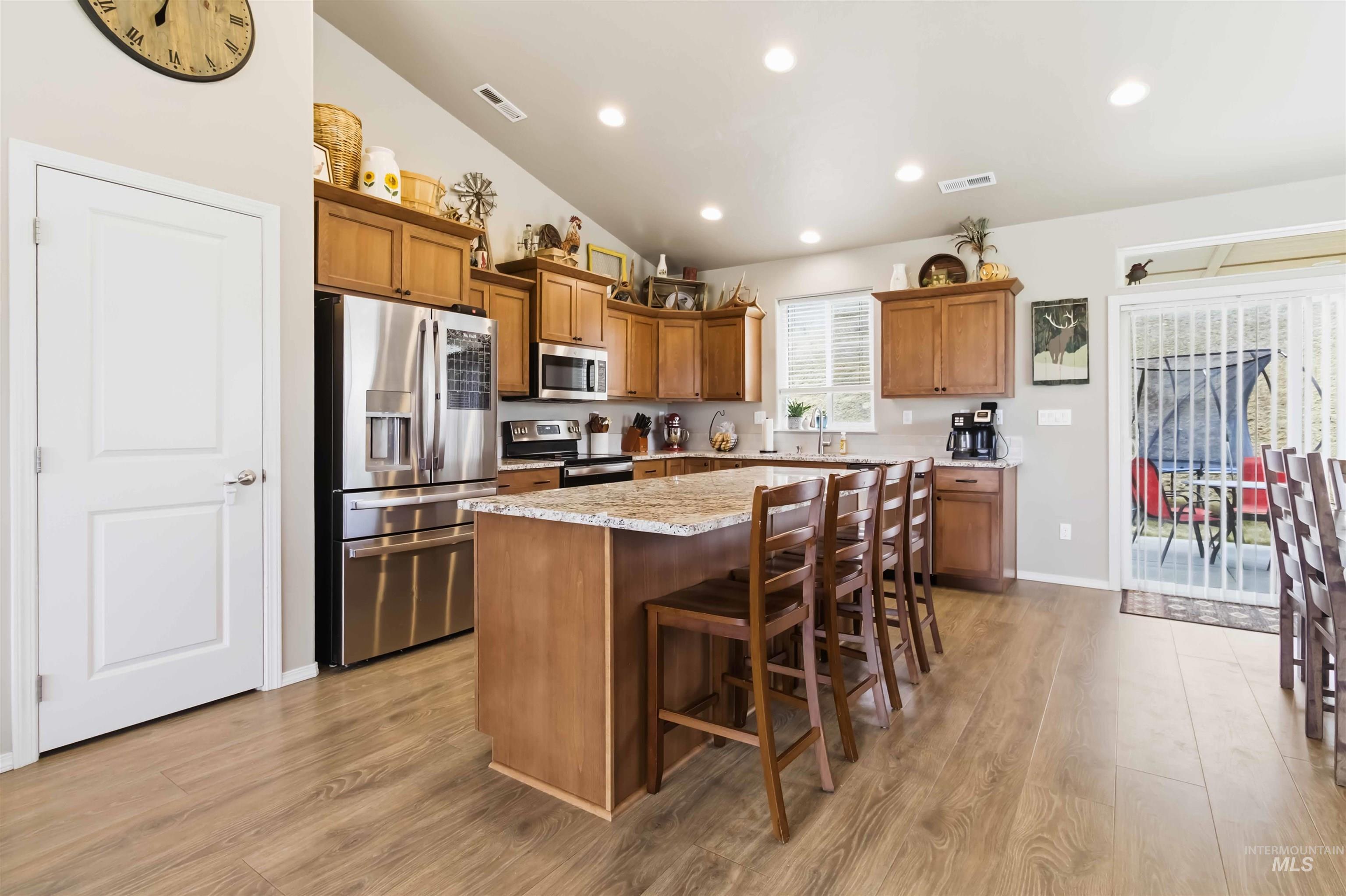 25 River Ridge Horseshoe Bend, ID 83629 - Photo 18 of 50 Kitchen with wood finish cabinets, stainless steel appliances, vaulted ceiling, a breakfast bar, and a center island
