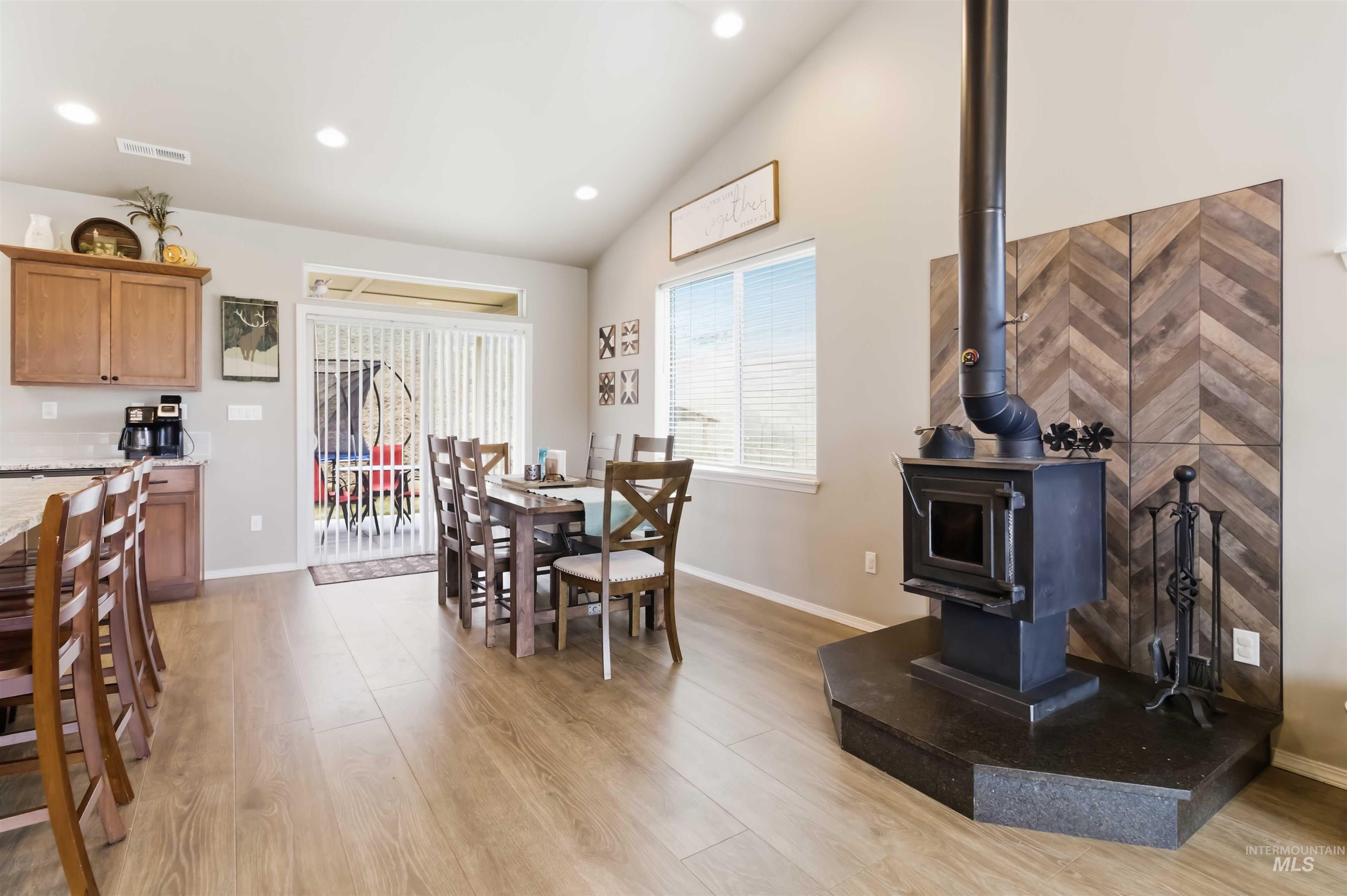 25 River Ridge Horseshoe Bend, ID 83629 - Photo 21 of 50 Dining space with vaulted ceiling, light wood-style floors, recessed lighting, and a wood stove