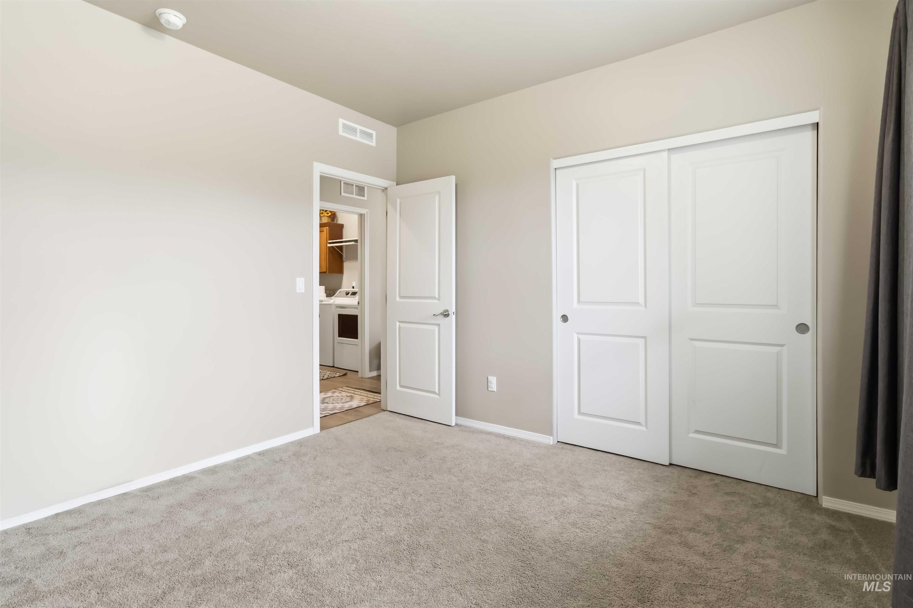 25 River Ridge Horseshoe Bend, ID 83629 - Photo 28 of 50 Unfurnished bedroom with light carpet, a closet, and washing machine and dryer