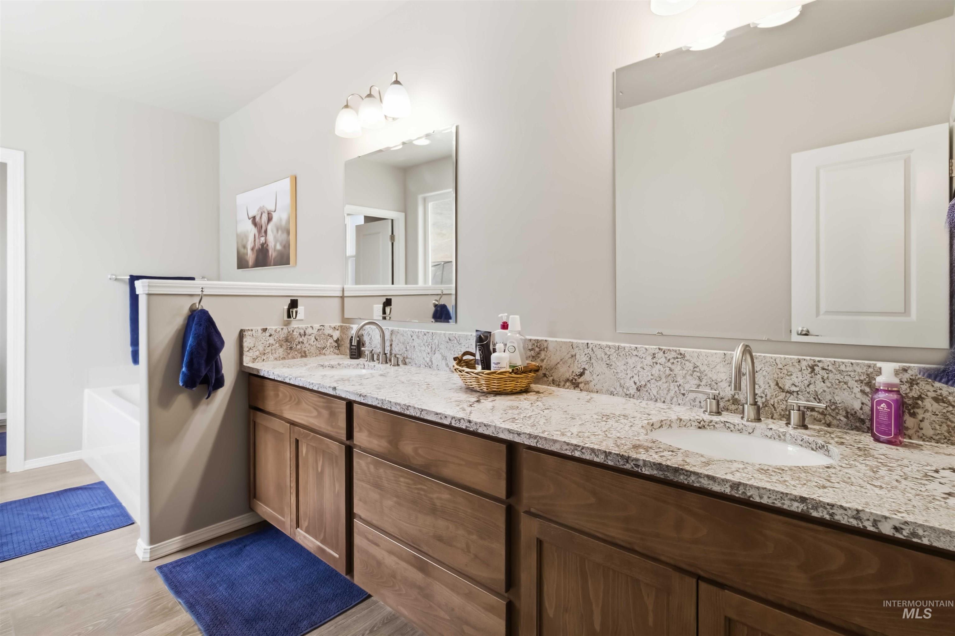 25 River Ridge Horseshoe Bend, ID 83629 - Photo 28 of 50 Bathroom featuring double vanity, a garden tub, and light wood-style flooring